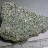 Riodacita (roca volcánica)
Mazarrón (Murcia, España)
Roca clara de grano fino, con minerales reconocibles.  Obsérvense los granos azules, probablemente de cordierita, según afirma la web antes citada. (Autor: prcantos)