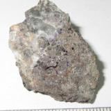 Greisen
Krupka, Bohemia, República Checa
3&rsquo;5 x 2 cm.
Un greisen de casiterita, producto del metasomatismo de granitoides en fase pneumatolítica, en el que junto a pequeños cristales negros de casiterita se perciben granos de color violeta de fluorita.  La cara oculta en esta fotografía contiene un cristal de casiterita que muestro en mi colección de minerales: http://www.foro-minerales.com/forum/viewtopic.php?p=86430#86430 . (Autor: prcantos)