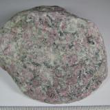 Naujaita
Complejo de Illimaussaq, Fiordo Kangerdlussaq, Julianebab District, Sur de Groenlandia
7 x 6.5 cm.
Variedad agpaítica de una sienita de nefelina y sodalita, caracterizada por una textura poiquilítica con prequeños cristales de sodalita (granos grises) incluidos en granos más grandes de feldespato alcalino, arfvedsonita, aegirina (negras) y eudialita (mineral rosa).  La sodalita da intensa fluorescencia de color naranja con luz ultravioleta. (Autor: prcantos)