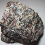 Granito
Grimstad, Aust-Agder, Noruega
10 x 10 cm.
El "granito Grimstad" es una plutonita de grano grueso con grandes feldespatos rojizos y abundantes componentes oscuros.  Con una edad de 980-1000 millones de años, procede de una pequeña intrusión postorogénica. (Autor: prcantos)