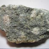 Microgabro (dolerita)
Mynydd Preseli (Preseli Hills), Pembrokeshire, Gales, Reino Unido
6 x 4 cm.
Esta dolerita porfídica de color verdoso con grandes granos claros, es la roca llamada "Preseli Bluestone", la roca empleada para construir Stonehenge (ver http://en.wikipedia.org/wiki/Bluestone#Bluestone_of_Stonehenge ; enlace normalizado por FMF).  Sin embargo, no son rocas autóctonas del lugar, sino que fueron llevadas hasta allí desde kilómetros de distancia, bien por un glaciar, bien por el hombre (como todo en Stonehenge, el transporte de los bloques también es un misterio...) (Autor: prcantos)