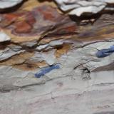 Photo 5. Several Carnegie type azurite suns exposed in the left hand corner of next face cut.  Directly underneath the thick right hand sun is the polished upper face of the dominant thrust plane found in the mine. You can trace the thrust plane to the left from this face. (Author: crocoite)